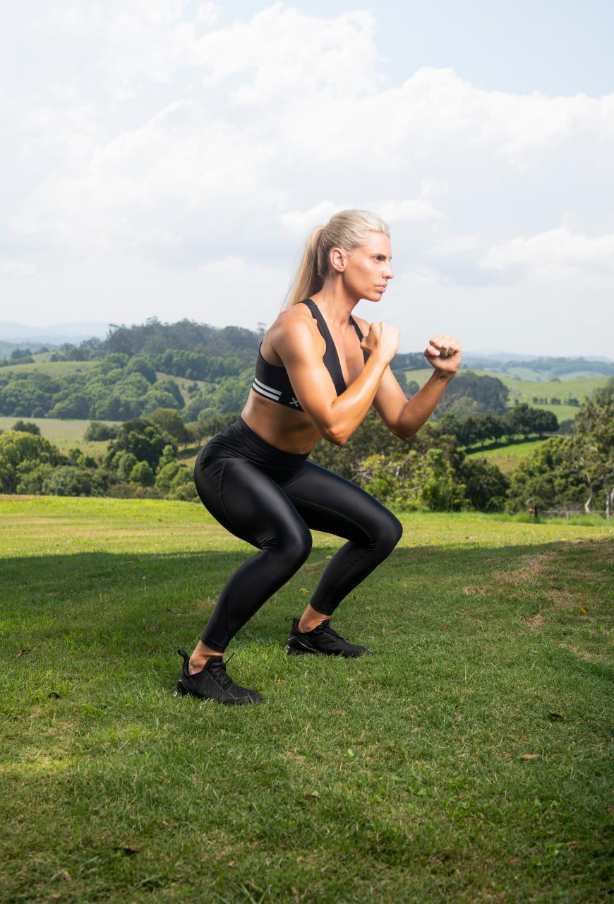 Trainer Tiffany Hall doing squats in the countryside